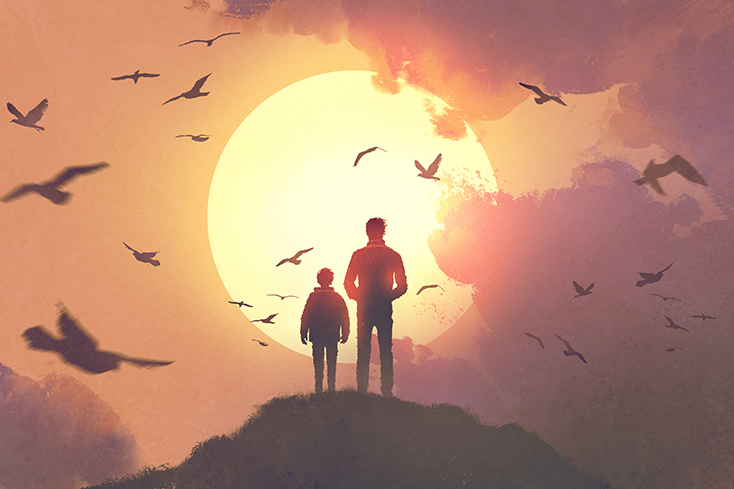 Man and boy standing on hill looking at sun