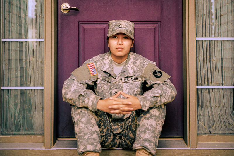 service member sitting in front of a door