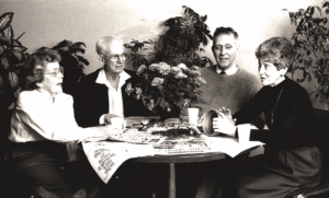 Four people meet and talk around a table