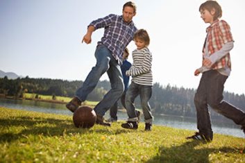 dad playing soccer with kids