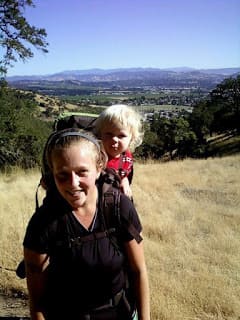 woman carrying a baby in a backpack carrier