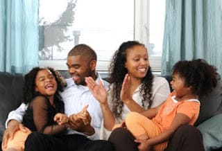 parents sitting on couch with 2 children