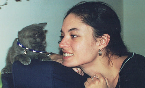 a woman smiling at a kitten