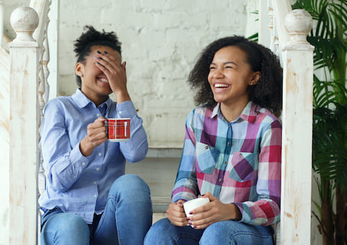 two women sitting on the steps laughing