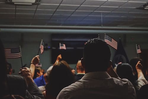 group of immigrants waving small American flags
