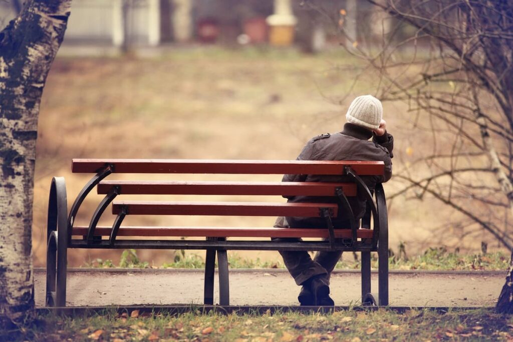 man sitting alone on a park bench