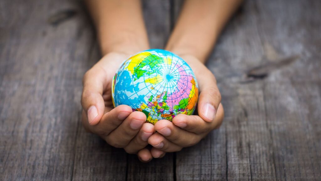 hands holding a small globe of the world