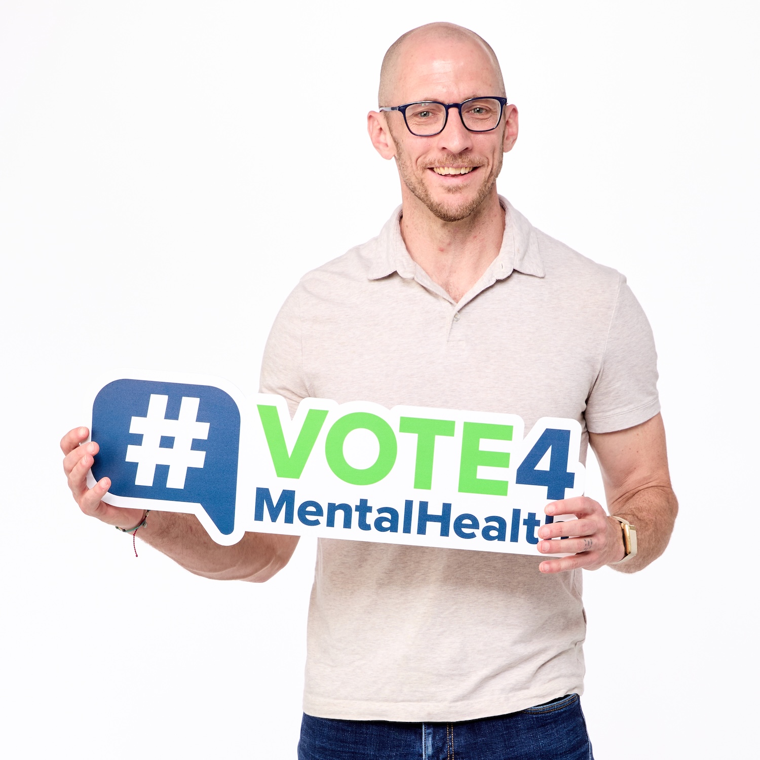 Man holding up a sign that reads "Vote 4 Mental Health"