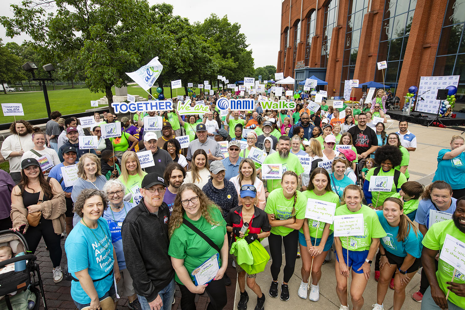 Large group of NAMIWalks participants smiling and holding signs